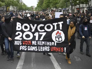 Sejumlah orang membawa spanduk saat menggelar demonstrasi di Paris, Prancis, Senin (8/5). Mereka menduga suara mereka tidak masuk ke dalam kotak suara yang memenangkan Emmanuel Macron. (AFP Photo/ Lionel BONAVENTURE)