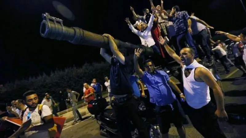 Orang-orang berdiri di depan tank di luar Bandara Ataturk Istanbul saat kudeta Turki. (Reuters)