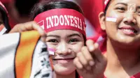 Seorang suporter menempelkan pipinya dengan stiker bendera Merah Putih untuk mendukung Timnas Indonesia U-22 pada laga lanjutan grup B SEA Games 2017 melawan Timor Leste, Minggu (20/8). Indonesia menang 1-0 atas Timor Leste. (Liputan6.com/Faizal Fanani)