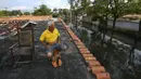 Oscar Delgado duduk di atap rumah tetangganya yang terendam banjir di Mata Redonda, Maracay, Venezuela, Rabu (21/10/2020). Hujan deras di negara bagian Aragua menyebabkan Sungai Madre Vieja meluap dan membanjiri beberapa wilayah. (AP Photo/Matias Delacroix)