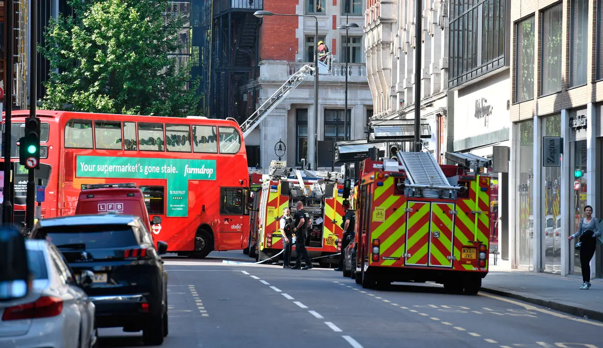 Petugas layanan darurat berkumpul saat terjadinya kebakaran di Hotel Mandarin Oriental, London, Inggris, Rabu (6/6). Belum diketahui apakah korban luka maupun tewas dalam insiden kebakaran itu. (John Stillwell/PA via AP)