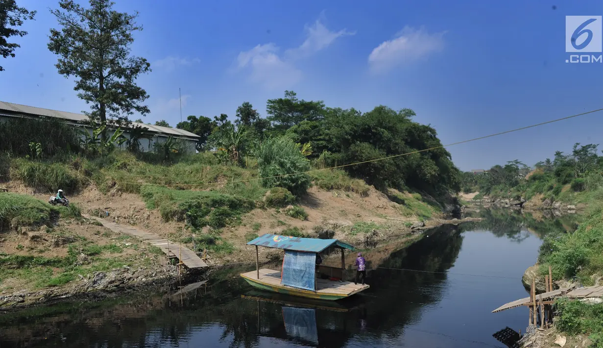 Nahkoda menarik perahu eretan di Sungai Cileungsi pebatasan Kabupaten Bogor-Kabupaten Bekasi, Bojong Kulur, Kabupaten Bogor, Jawa Barat, Selasa (23/7/2019).  Perahu eretan digunakan warga sebagai jalan alternatif dengan membayar Rp2.000 perorang untuk sekali menyeberang. (merdeka.com/Arie Basuki)