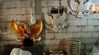 Perajin menyelesaikan pembuatan patung Garuda Pancasila yang terbuat dari serat kaca (fiberglas) di kawasan Kalimalang, Jakarta Timur, Selasa (16/8/2022). Jelang HUT Kemerdekaan RI, permintaan patung Garuda Pancasila meningkat hingga 80 persen. (merdeka.com/Arie Basuki)