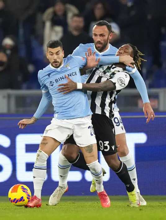 Pemain Lazio Mattia Zaccagni (depan) mendorong pemain Udinese Brandon Soppy disaksikan rekan setimnya Vedat Muriqi pada pertandingan sepak bola Coppa Italia di Olympic Stadium, Roma, Italia, 18 Januari 2021. Lazio menang dengan skor 1-0. (AP Photo/Andrew Medichini)