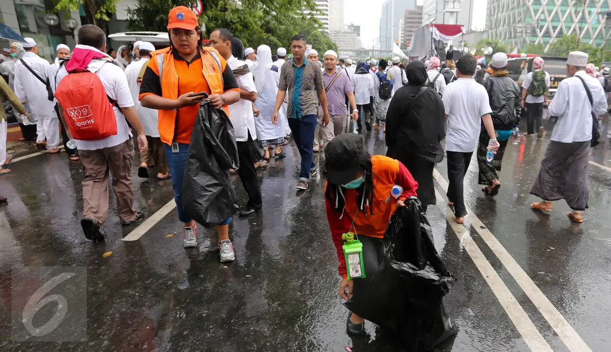 Dua petugas kebersihan DKI Jakarta membersihkan sampah usai aksi damai 2 Desember di kawasan Jalan MH Thamrin, Jakarta, Jumat (2/12). Aksi damai 2 Desember digelar sebagai lanjutan dari aksi 4 November 2016. (Liputan6.com/Ferbian Pradolo)
