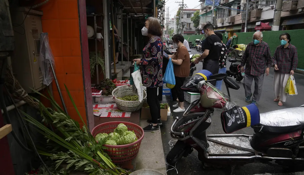 Warga membeli sayuran di toko di Shanghai (2/6/2022). Lalu lintas, pejalan kaki dan pelari muncul kembali di jalan-jalan Shanghai ketika kota terbesar di China mulai kembali normal di tengah pelonggaran penguncian COVID-19 dua bulan yang ketat atas penerapannya. (AP Photo/Ng Han Guan)