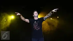 Vokalis Simple Plan, Pierre Bouvier mengajak penonton ikut bernyanyi dalam konser di Ecovention Eco Park, Ancol, Jakarta, Minggu (4/9). Konser bertajuk Taking One for The Team Tour ini merupakan promosi album terbaru tersebut. (Liputan6.com/Faizal Fanani)