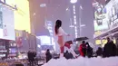 Seorang wanita berfoto di tengah salju di Times Square, New York, Amerika Serika (16/12/2020). Badai salju besar pertama di musim ini menyebabkan badai salju besar di tiga negara bagian, menumpahkan lebih dari satu kaki salju di beberapa bagian. (Xinhua/Wang Ying)