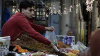 Pedagang Palestina menjual kurma dan rempah-rempah di sebuah pasar menjelang bulan suci Ramadan di Gaza City pada 20 April 2020. Diberlakukannya larangan keluar rumah atau jam malam membuat miliar umat muslim di dunia akan menjalani Ramadan yang berbeda tidak seperti sebelumnya (Xinhua/Yasser Qudih)