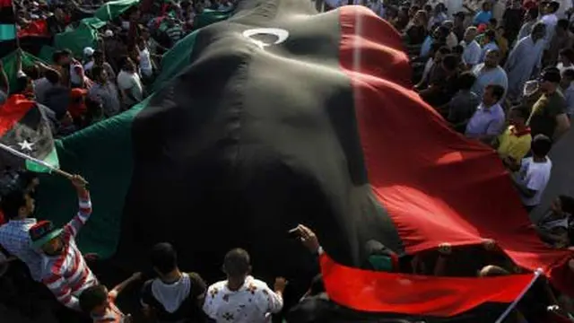 Para pengunjuk rasa membawa bendera raksasa Kerajaan Libya saat aksi menentang pemimpin Libya Muammar Gaddafi di Misrata, Rabu (6/7).(Antara)
