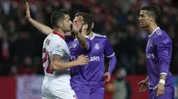 Gelandang Sevilla, Vitolo, berdebat dengan bintang Real Madrid, Cristiano Ronaldo. Pada laga yang berjalan keras ini wasit mengeluarkan tiga kartu kuning untuk Sevilla dan satu untuk Madrid. (AFP/Jorge Guerrero)