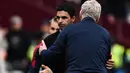 Ekspresi kecewa pelatih Arsenal, Mikel Arteta saat berpelukan dengan pelatih West Ham United, David Moyes setelah berakhirnya laga pekan ke-31 Liga Inggris 2022/2023 di London Stadium, London (17/4/2023). (AFP/Ben Stansall)