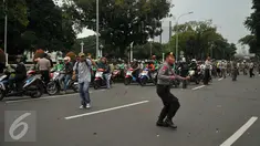 Pengemudi ojek online dilempari batu oleh sopir taksi yang melakukan unjuk rasa di depan Istana Negara, Jakarta, Selasa (22/3). Aksi itu pecah saat pengunjuk rasa mendapat ejekan dari pengemudi ojek online. (Liputan6.com/Gempur M Surya)