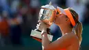 Maria Sharapova mencium trofi Perancis Terbuka usai mengalahkan petenis Rumania, Simona Halep di Stadion Roland Garros, Paris, (7/6/2014). (REUTERS/Vincent Kessler)