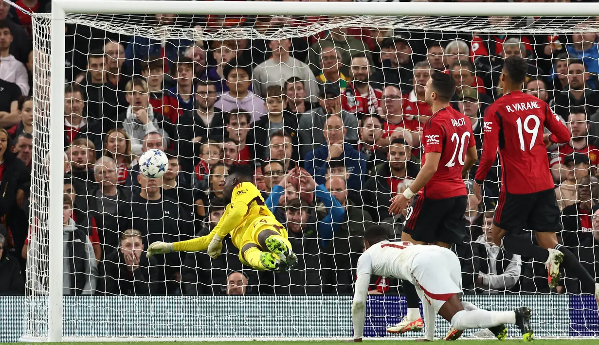 Penjaga gawang MU, Andre Onana (kiri), tidak dapat menghalau bola tendangan dari pemain Galatasaray, Wilfried Zaha, dalam pertandingan lanjutan Grup A Liga Champions 2023/2024 yang berlangsung di Old Trafford, Manchester, Rabu (4/10/2023) dini hari WIB. (AFP/Darren Staples)