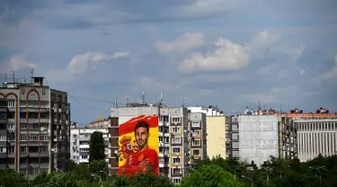 Sebuah mural raksasa begambar bek Spanyol Sergio Ramos terlihat di sebuah bangunan perumahan di Krasnodar, Rusia, Rabu (6/6). Ramos mendapat sambutan hangat di Krasnador. (Pierre-Philippe MARCOU/AFP)