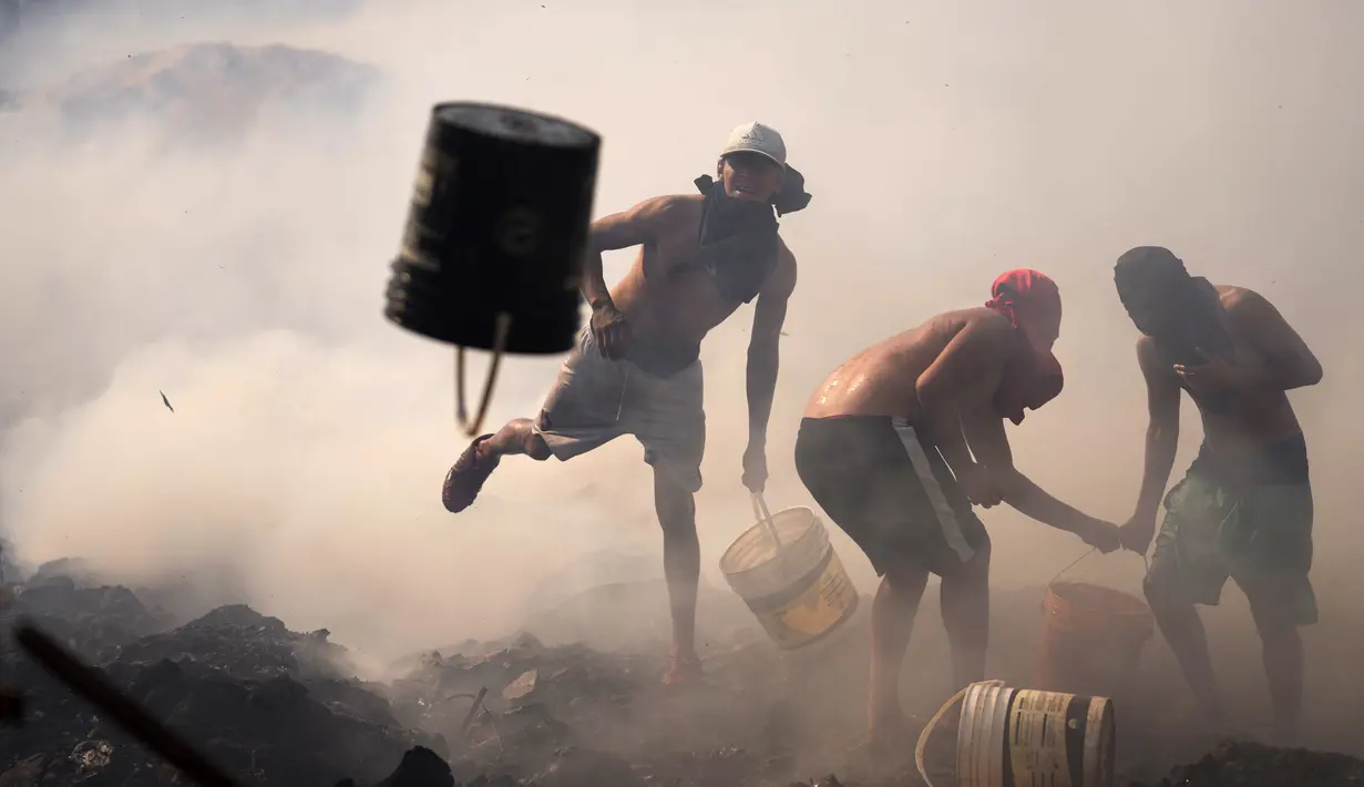 Warga berusaha memadamkan api dengan ember berisi air di Santa Ana, Asuncion, Paraguay, Kamis (19/8/2021). Api yang membakar kawasan pemukiman warga berpenghasilan rendah itu bermula dari orang-orang yang membakar sampah kemudian menjalar dan menghancurkan selusin rumah. (AP Photo/Jorge Saenz)