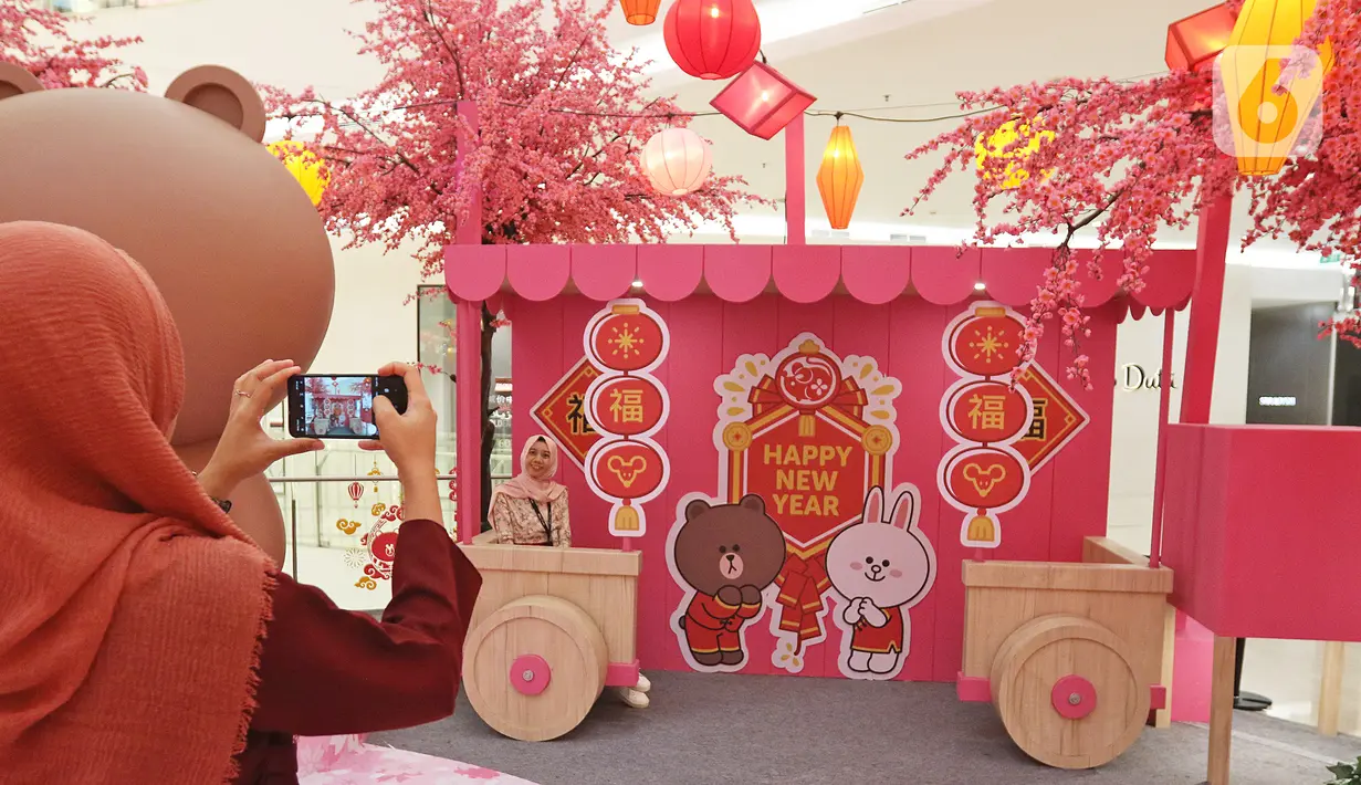 Pengunjung foto disamping instalasi BT21 di Atrium Senayan City, Jakarta, Rabu (22/1/2020). Jelang Tahun Baru Imlek, Senayan City menghadirkan instalasi Mega Brown setinggi 2,5 meter dan Pop Up Shop terbesar yang bisa dinikmati mulai 17 Januari sampai 9 Februari 2020. (Liputan6.com/Herman Zakharia)