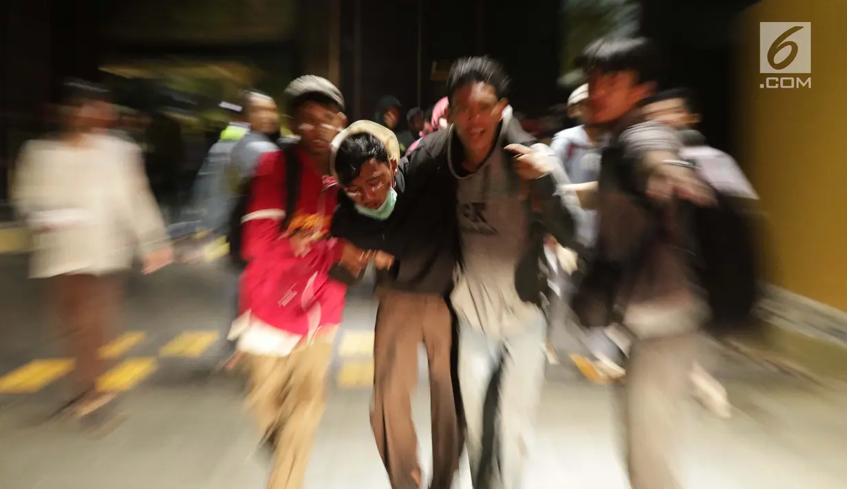Sejumlah pelajar membantu rekan mereka yang terluka dalam demonstrasi berujung ricuh di Pejompongan, Jakarta, Rabu (25/9/2019). Sebelumnya, ribuan pelajar yang melangsungkan demonstrasi di Gedung DPR terlibat bentrok dengan polisi. (Liputan6.com/Helmi Fithriansyah)