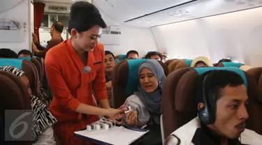 Pramugari membagikan cokelat kepada penumpang dalam penerbangan di Pesawat Garuda Indonesia menuju, Padang, Sumatera Barat, Jumat (21/4). Dalam rangka menyambut Hari Kartini, penerbangan Garuda Indonesia diawaki oleh perempuan. (Liputan6.com/Angga Yuniar)