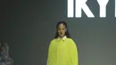 IKYK menampilan warna-warna cerah, seperti dress asimetris plisket warna hijau neon dengan gaya layering mengenakan inner kemeja panjang dan rok hitamnya.  [Fimela/Daniel Kampua]
