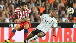 Penyerang Atletico Madrid, Angel Correa (kiri) berebut bola dengan penyerang Valencia, Samuel Lino selama pertandingan lanjutan La Liga Spanyol di stadion Mestalla di Valencia (30/8/2022). Atletico Madrid menang tipis atas tuan rumah Valencia 1-0. (AFP/Jose Jordan)
