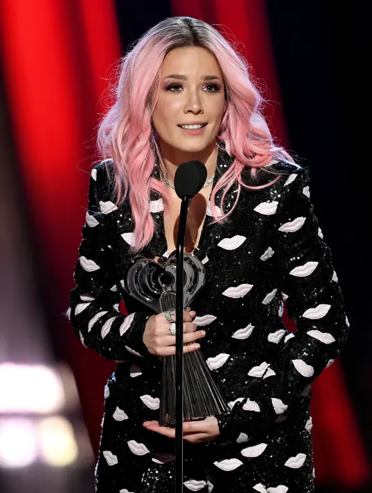 Halsey sebagai pemenang dalam kategori Fangirls Awards iHeartRadio Music Awards 2019 pada 15 Maret yang lalu. Dengan rambut bewarna merah jambunya dan baju hitam dengan corak bibir, Halsey nampak gembira memenangkan penghargaan tersebut. (Kapanlagi/AFP)