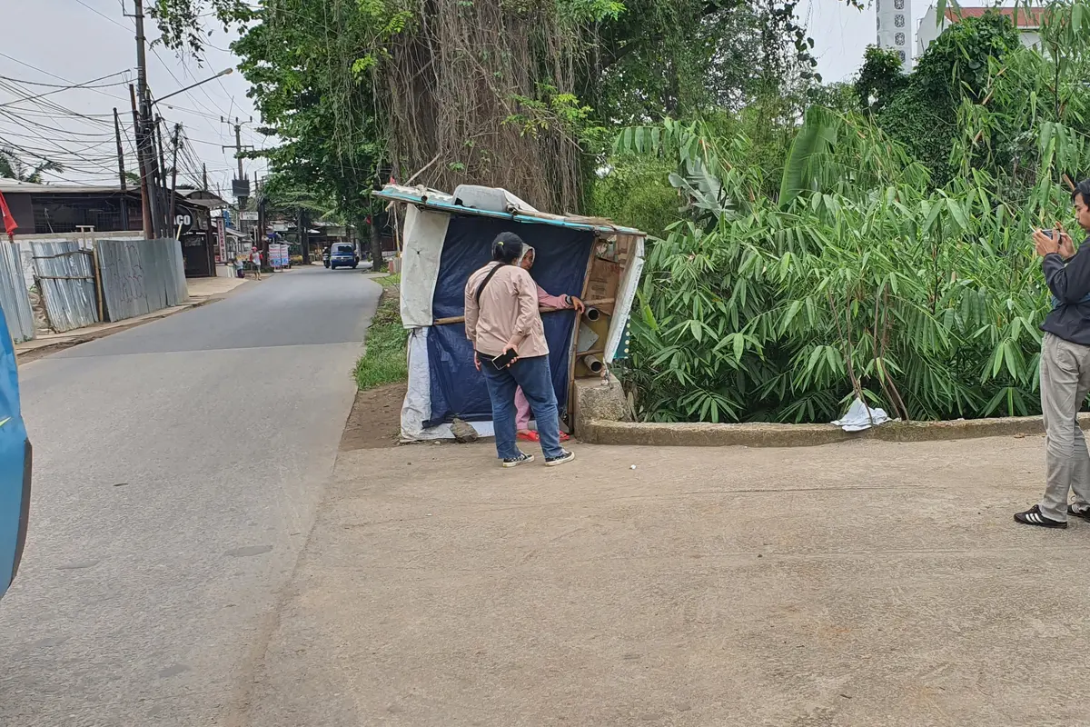 Pemilik warung menunjukan lokasi penemuan bungkusan mencurigakan di warungnya di Depok.