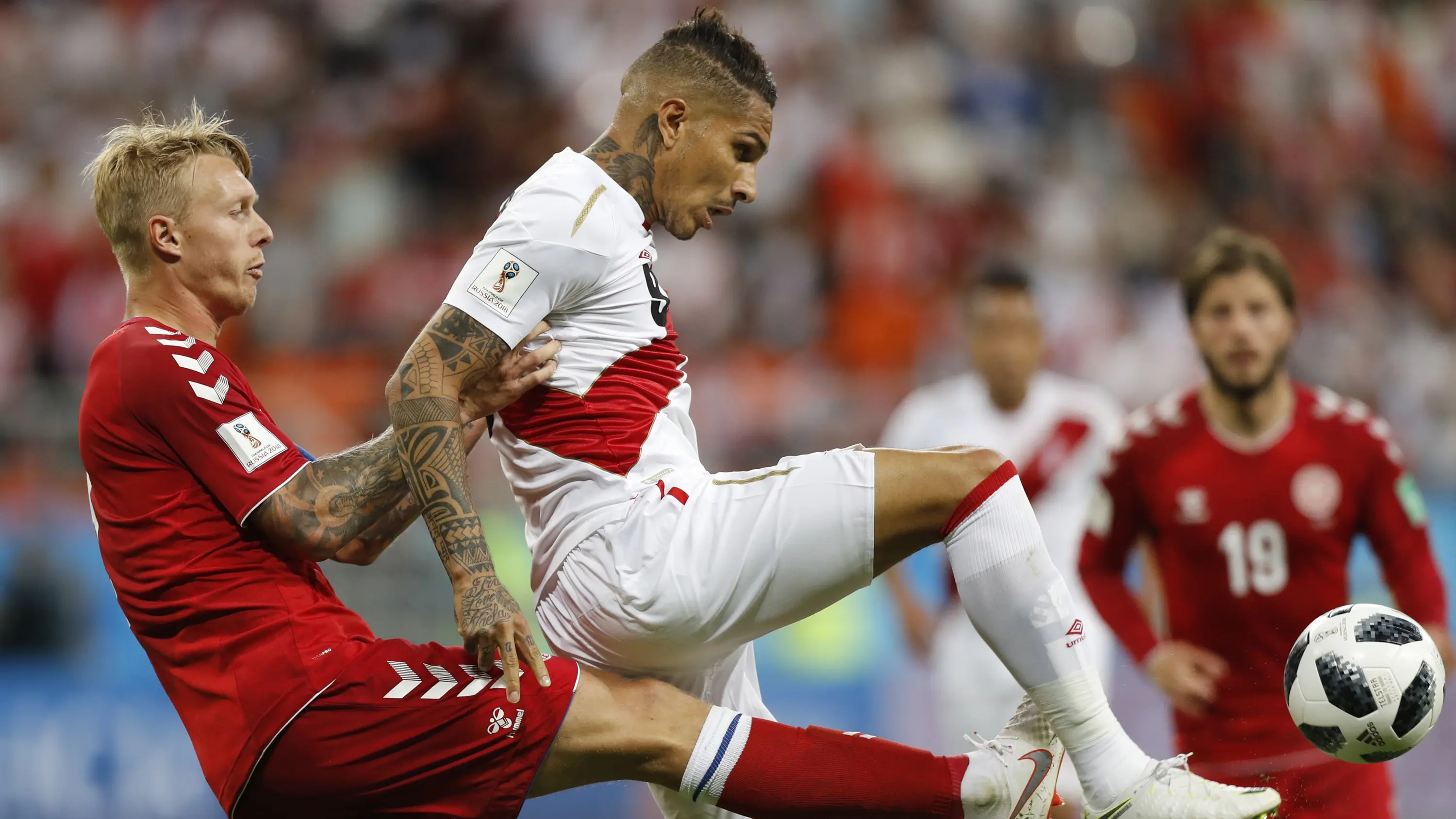 Striker Peru, Paulo Guerrero, berebut bola dengan bek Denmark, Simon Kjaer, pada laga Grup C Piala Dunia di Mordovia Arena, Saransk, Sabtu (16/6/2018). (AP/Efrem Lukatsky)