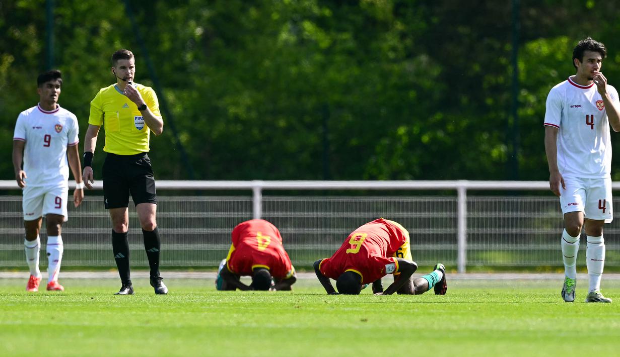 Sujud syukur dua pemain Guinea U-23 merayakan kemenangan 1-0 atas Timnas Indonesia U-23 tak lama setelah wasit Francois Letexier meniup peluit akhir laga play-off antar-konfederasi menuju Olimpiade Paris 2024 di Stade Pierre Pibarot, Centre National du Football de Clairefontaine, Prancis, Kamis (9/5/2024). (AFP/Miguel Medina)