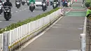 Kendaraan melintas di samping jalur khusus sepeda yang diberikan pembatas jalur permanen di Jalan Sudirman, Jakarta, Kamis (17/6/2021). Kapolri Jenderal Listyo Sigit Prabowo akan membongkar jalur sepeda di Sudirman-Thamrin dan mempelajari jalur sepeda di negara lain. (Liputan6.com/Faizal Fanani)