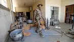 Seorang pasukan anggota pasukan kontraterorisme Irak melintas di bangunan yang digunakan sebagai pabrik senjata militan ISIS yang berhasil ditemukan di Fallujah, Irak, Kamis (23/6). (REUTERS/Thaier Al-Sudani)