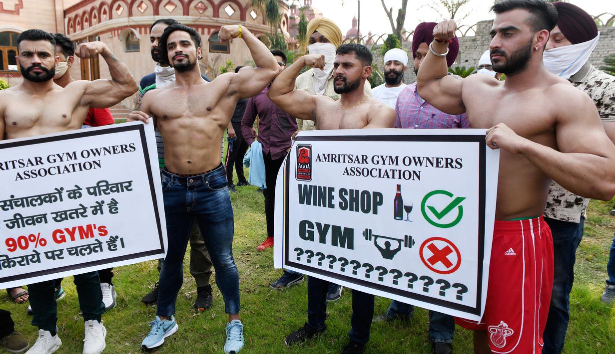 Pemilik dan pelatih gym memegang spanduk saat protes menuntut pemerintah membuka kembali pusat kebugaran di Amritsar, India, Minggu (7/6/2020). Mereka meminta aktivitas tempat olahraga gym juga diizinkan buka setelah pelonggaran lockdown, bukan hanya kegiatan perekonomian.  (NARINDER NANU/AFP)