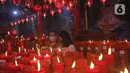 Warga keturunan Tionghoa menyalakan lilin di Klenteng Hok Lay Kiong, Bekasi, Kamis (11/2/2021). Sembahyang di malam Imlek ini sebagai ungkapan syukur atas rezeki dan keselamatan dari Tuhan serta untuk pengharapan kehidupan lebih baik di tahun Kerbau. (Liputan6.com/Herman Zakharia)