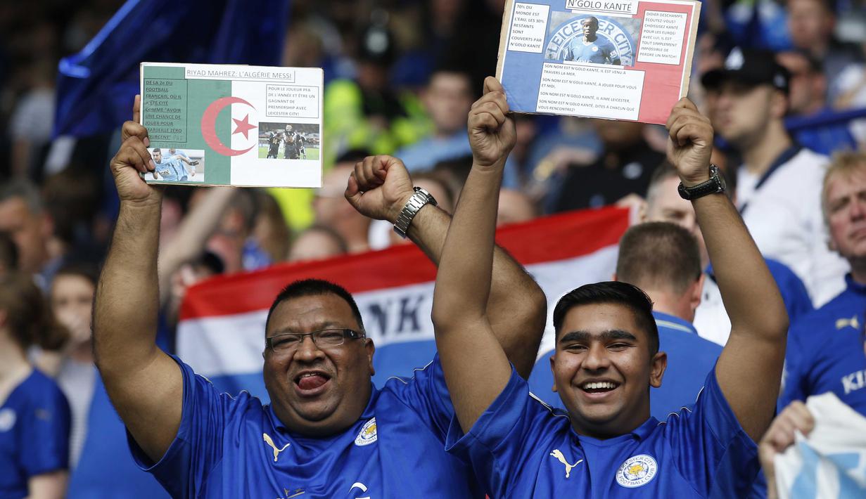 Suporter Leicester City memegang poster N'Golo Kante (keturunan Mali) dan Riyad Mahrez (keturunan Algeria) saat merayakan gelar juara Liga Inggris di Stadion King Power, Leicester, Inggris. (7/5/2016). (Action Images via Reuters/Carl Recine)