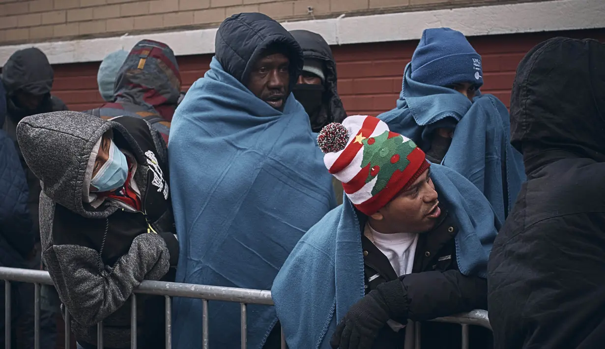 Para migran menunggu dalam cuaca dingin saat mereka mencari perlindungan di luar Pusat Bantuan Migran di Sekolah Dasar St. Brigid, New York pada Rabu, 29 November 2023. (AP Photo/Andres Kudacki)