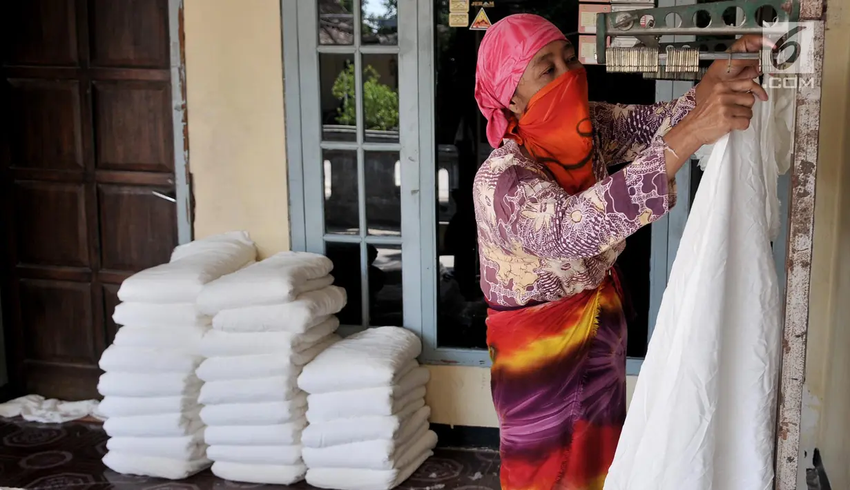 Pekerja saat melakukan pemotongan kain di salah satu industri rumahan di Desa Krajan, Mojolaban, Sukoharjo, Jawa Tengah, Senin (10/6/2019). (merdeka.com/Iqbal S. Nugroho)