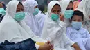 Umat muslim mengenakan masker saat mendengarkan ceramah usai melaksanakan salat Idul Adha di halaman Masjid Raya Annur, Kota Pekanbaru, Riau, Minggu (11/8/2019). Kabut asap imbas kebakaran hutan dan lahan (karhutla) menyelimuti pelaksanaan salat Idul Adha 2019 di Pekanbaru. (Wahyudi/AFP)