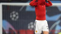 Pemain Manchester United (MU), Diogo Dalot, menutupi wajahnya dengan kostum timnya setelah kalah dari Bayern Munchen pada laga matchday keenam Liga Champions 2023/2024, Rabu (13/12/2023) dini hari WIB. MU kalah 0-1 dalam laga tersebut dan tersingkir dari Liga Champions. (PETER POWELL / AFP)
