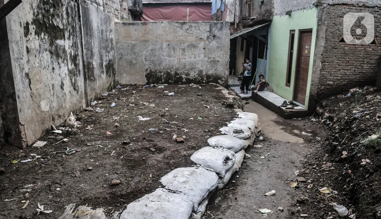Warga berada di salah satu rumah yang rusak akibat sering terendam banjir di kawasan RW 07 Rawajati, Jakarta, Selasa (22/9/2020). Meskipun banjir yang datang pada Senin (21/9) malam telah surut, warga tetap bersiaga apabila banjir kiriman kembali datang. (merdeka.com/Iqbal S. Nugroho)