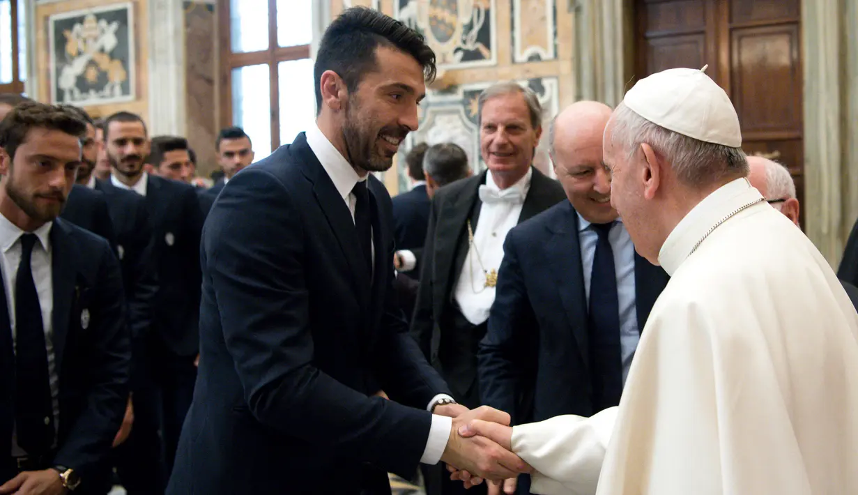 Paus Fransiskus (kanan) bersalaman dengan Kiper Juventus, Gianluigi Buffon di akhir audiensi dengan pemain Juventus dan Lazio pada malam menjelang final Piala Tim pada 16 Mei 2017. (AFP/Osservatore Romano)