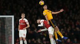 Shkordan Mustafi berduel dengan pemain Wolverhampton pada Wolverhampton pada laga lanjutan Premier League, yang berlangsung Minggu (11/11) di stadion Emirates. Arsenal ditahan imbang Wolverhampton 1-1. (AFP/Daniel Olivas)