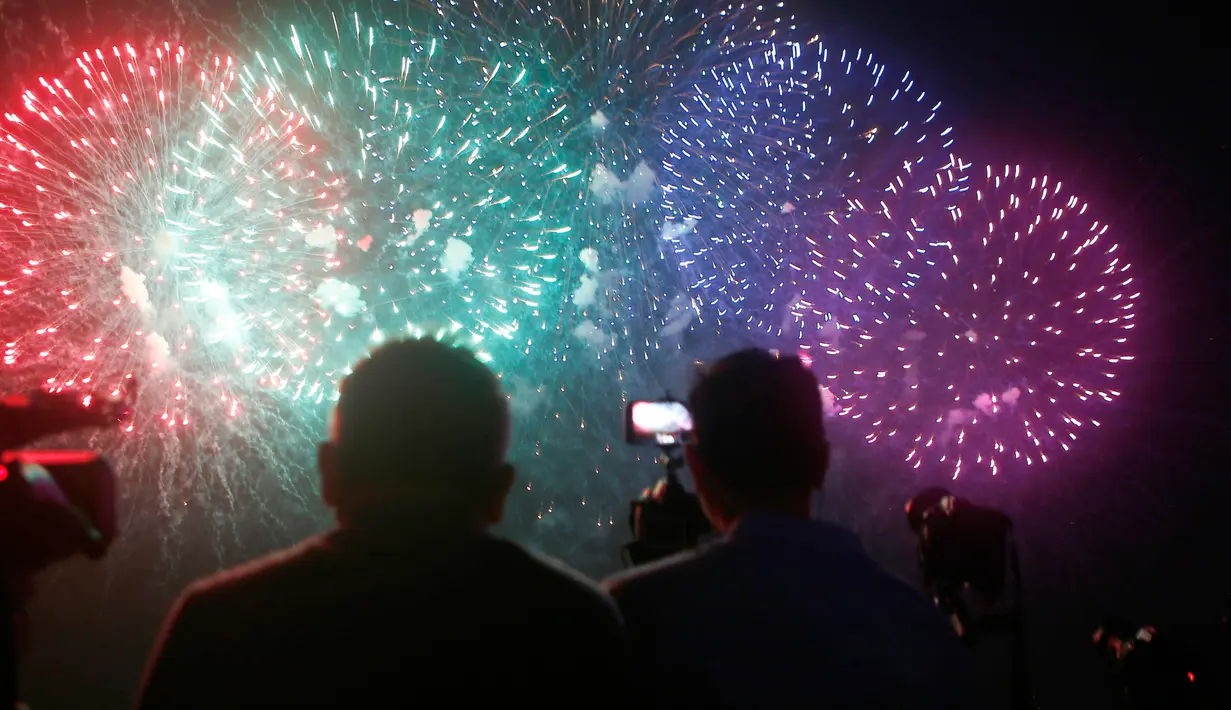 Penonton menyaksikan pertunjukan kembang api dari salah satu peserta dalam puncak kompetisi Pyromusical Internasional ke-9 di Filipina, Sabtu (24/3). Peserta kompetisi adalah para maestro kembang api kelas dunia dari berbagai negara. (AP/Bullit Marquez)