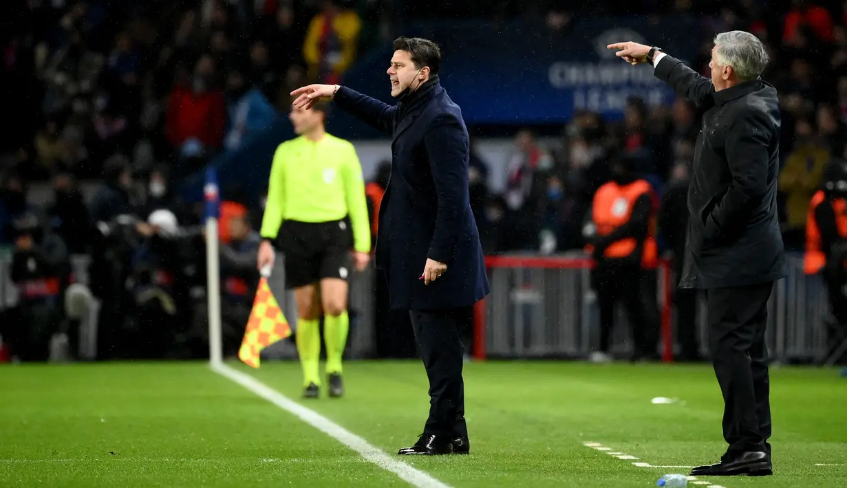 Pelatih Paris Saint-Germain Mauricio Pochettino (tengah) dan pelatih Real Madrid Carlo Ancelotti (kanan) memberi isyarat selama pertandingan sepak bola leg pertama babak 16 besar Liga Champions UEFA antara PSG dan Real Madrid di Parc des Stadion Princes di Paris pada 15 Februari 2022. (FRANCK FIFE / AFP)
