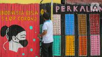 Warga membuat mural Lawan Virus Corona di Lapangan Bulutangkis, Kampung Kali Pasir, Jakarta, Selasa (7/4/2020). Mural dengan swadaya sendiri mengajak warga untuk memutus rantai penyebaran Corona Covid-19 dengan diam di rumah dan tidak berkerumum di luar. (Liputan6.com/Fery Pradolo)