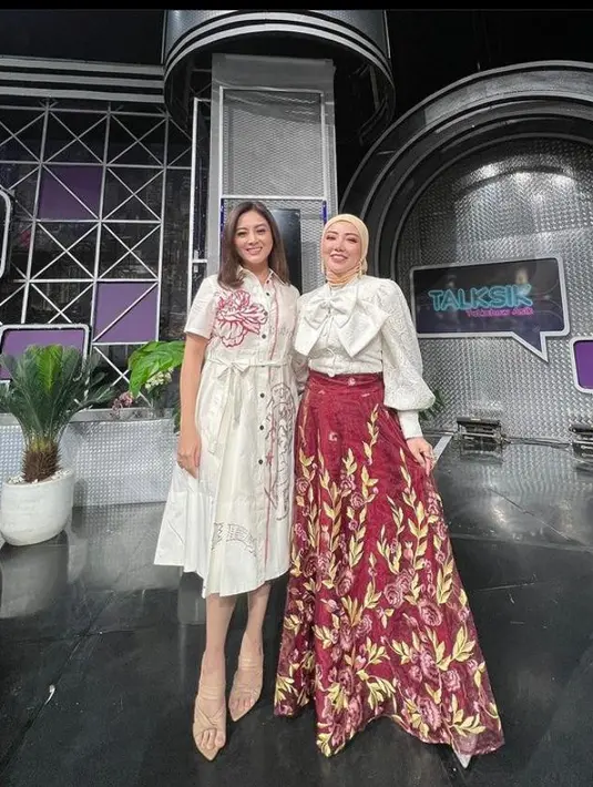 Seperti potret ini, ia tampil modis memadukan blouse putih dan long skirt bermotif warna merah serta hijab warna krem saat menghadiri acara talkshow. (Instagram/bellashofie_rigan).