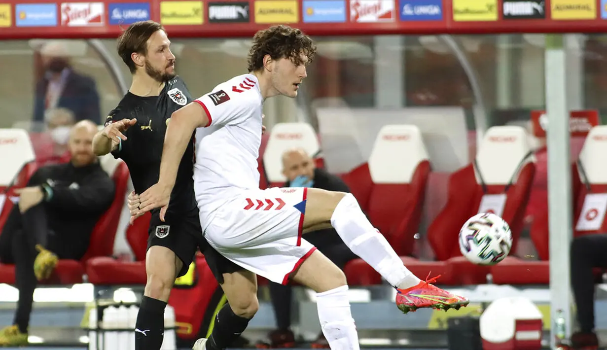 Pemain Denmark Jonas Wind (kanan) memperebutkan bola dengan pemain Austria Andreas Ulmer pada pertandingan Grup F kualifikasi Piala Dunia 2022 di Ernst-Happel-Stadium, Wina, Austria, Rabu (31/3/2021). Denmark membantai Austria 4-0. (AP Photo/Ronald Zak)
