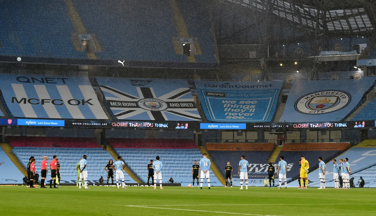 Para pemain mengheningkan cipta satu menit jelang laga Premier League antara Manchester City dan Arsenal di Etihad Stadium, Manchester, Inggris, Rabu (17/6/2020). Manchester City menang dengan skor 3-0. (PETER POWELL/POOL/AFP)