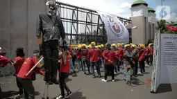 Elemen buruh menggelar aksi unjuk rasa di gedung DPR RI, Jakarta, Selasa (10/1/2023). Massa aksi yang menolak Perppu Cipta Kerja tersebut terlihat membawa bendera berwarna merah memenuhi halaman depan gedung DPR. (Liputan6.com/Faizal Fanani)