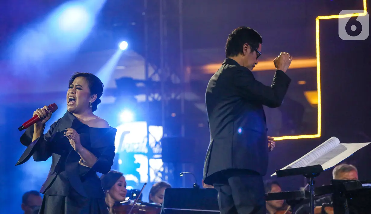 Penyanyi Rita Effendi bersama Twilite Orchestra saat membawakan lagu bertema Symphony Under the Stars: Movie Fest II di Lippo Mall Kemang, Jakarta, Sabtu (26/10/2019). 13 Soundtrack film Indonesia maupun mancanegara disajikan dalam outdoor orchestra concert. (Liputan6.com/Fery Pradolo)